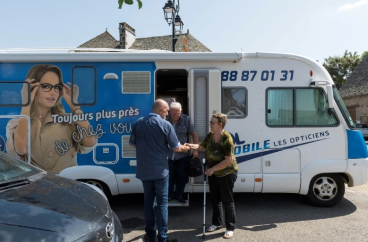 Yves Thevenoux (G), un opticien itinérant du Cantal, accueille des patients le 24 juillet 2019 à Montsalvy