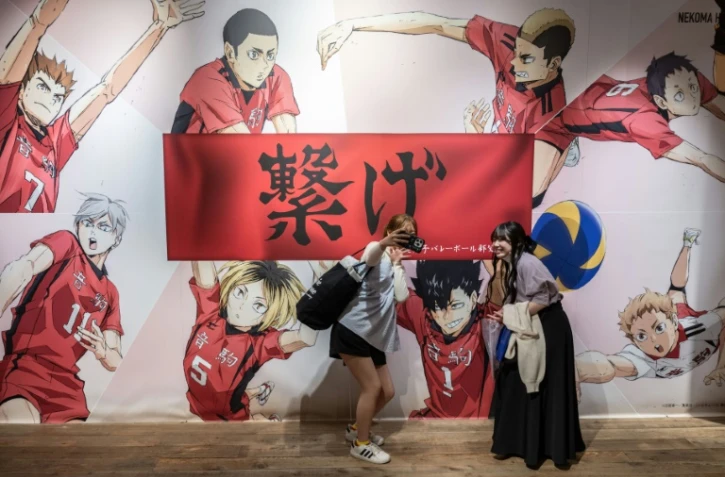 Des jeunes femmes font un selfie dans un magasin éphémère consacré au manga japonais de volley-ball "Haikyu !!", le 19 avril 2024 à Tokyo