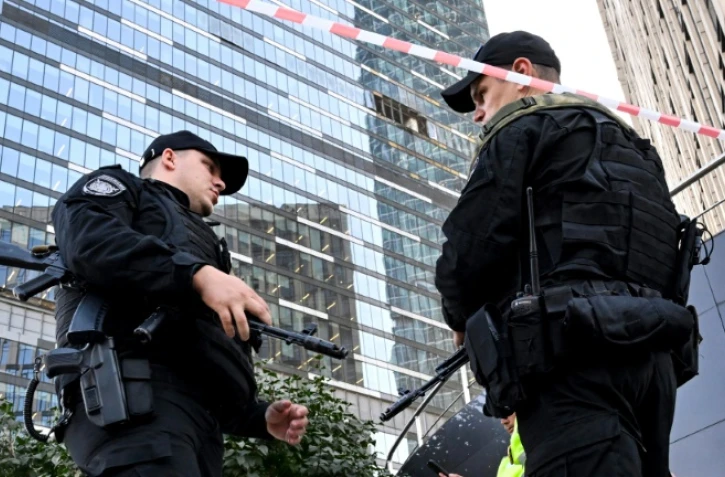Deux agents de police bouclent le périmètre autour d'un immeuble de bureaux endommagé de Moscou City après une attaque de drone rapportée par la Russie, le 1er août 2023 à Moscou