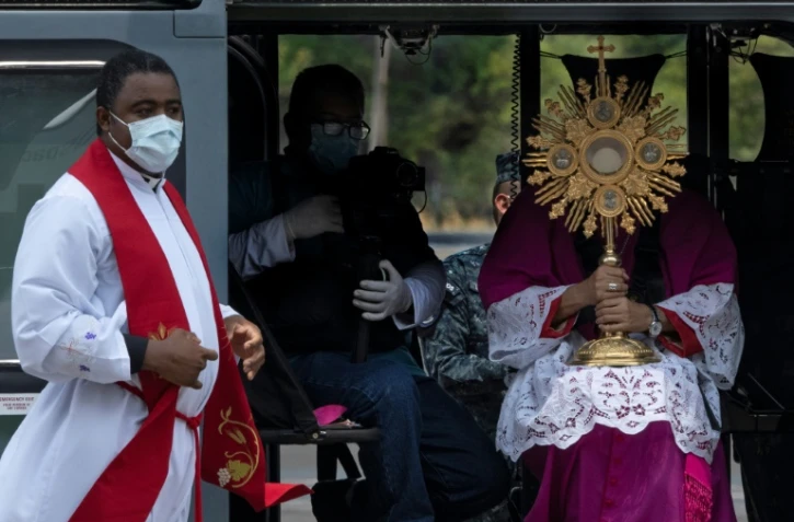 L'archevêque du Panama, José Domingo Ulloa (d) tient un ostensoir à bord d'un hélicoptère, le 5 avril 2020 à Panama 