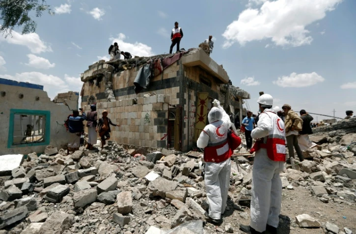 Des employés du Croissant Rouge du Yémen et des civils à Arhab, localité située à la sortie nord de Sanaa, sur le site frappé par un raid aérien, le 23 août 2017