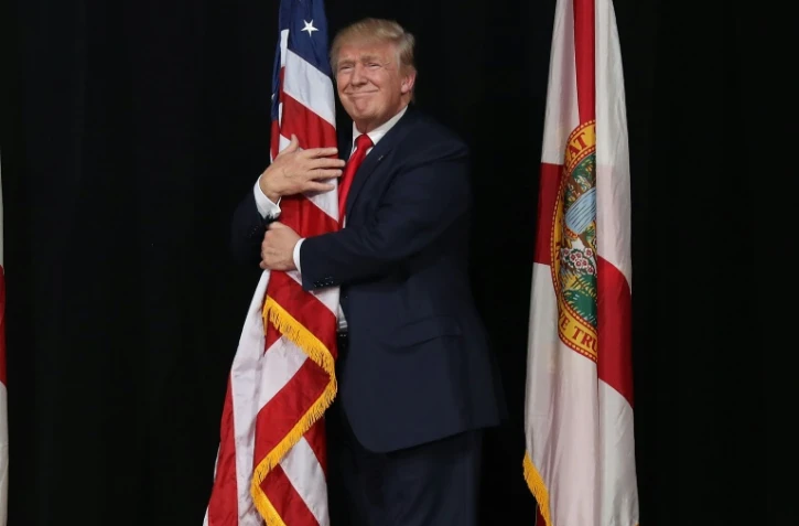 Donald Trump enlace le drapeau américain, le 24 octobre 2016 à Tampa (Floride)