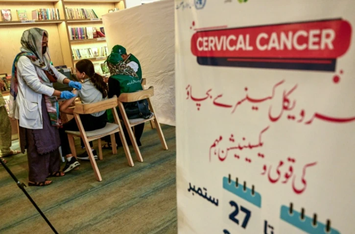 Une soignante (g) administre le vaccin contre le virus du papillome humain (VPH) à une adolescente, lors d'une campagne de vaccination contre le cancer du col de l'utérus, le 24 septembre 2025 à Karachi, au Pakistan
