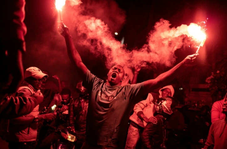 Des Dakarois célèbrent la libération de l'opposant sénégalais Ousmane Sonko et du candidat à la présidentielle Bassirou Diomaye Faye, à Dakar le 15 mars 2024