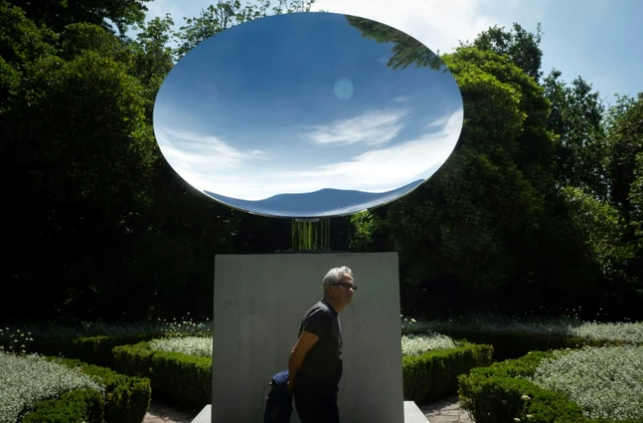 Le sculpteur britannique Anish Kapoor devant son oeuvre "Sky Mirror" lors de la présentation de l'exposition "Anish Kapoor: ?uvres, pensées, expériences", le 6 juillet 2018 dans le parc de la Fondation Serralves, à Port, au Portugal