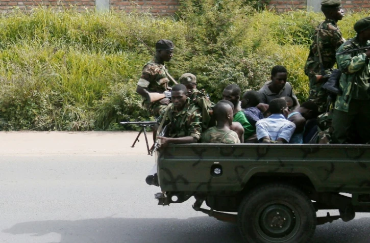 Un véhicule militaire avec des hommes menottés circule dans Bujumbura le 11 décembre 2015