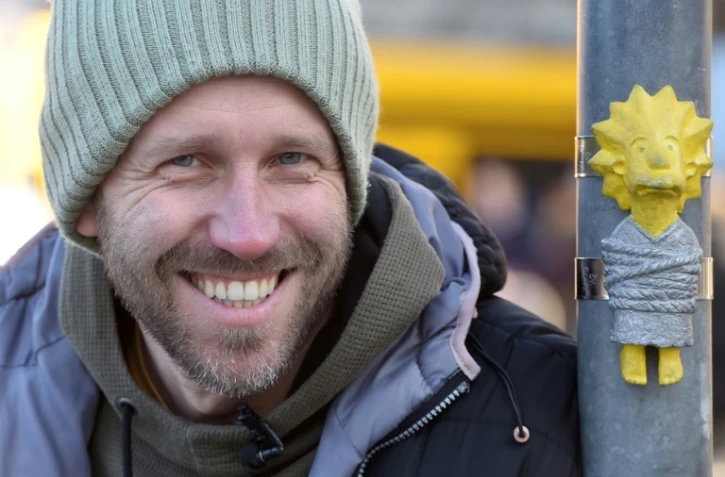 Mihaly Kolodko à coté d'une de ses petites statues "Lisa", un personnage des Simpsons, à Budapest, le 11 décembre 2019