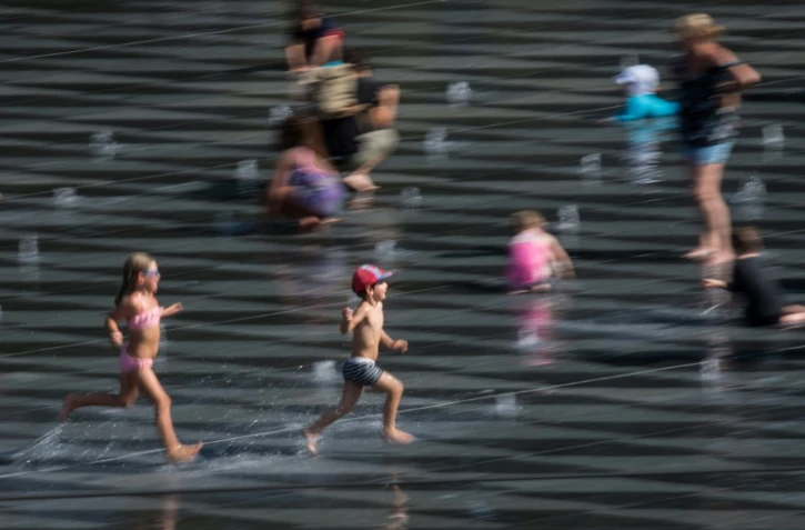 Des enfants jouent sur le Miroir d'Eau à Nantes, dans l'ouest de la France, le 24 juillet 2019