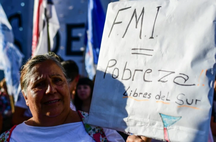 Une manifestante brandit le message "FMI = pauvreté" devant le Parlement argentin à Buenos Aires, le 12 février 2020