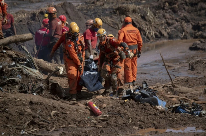 Des secouristes transportent un corps après la rupture d'un barrage près de Brumadinho au Brésil, le 28 janvier 2019