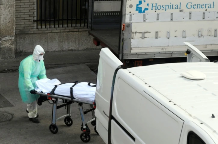 Un corps est transporté hors de l'hôpital Gregorio Maranon, à Madrid, le 25 mars 2020
