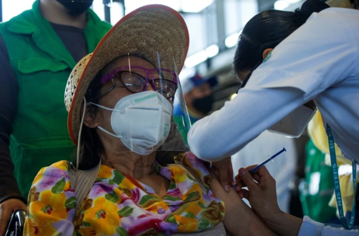 Una Mexicaine se fait vacciner contre le Covid-19 à l'Université autonome de Mexico, à Mexico, le 24 mars 2021