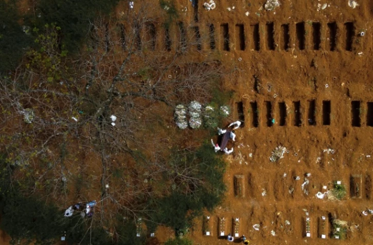 Vue aérienne de la mise en terre d'un cercueil au cimetière de Vila Formosa à Sao Paulo, au Brésil, le 14 avril 2021