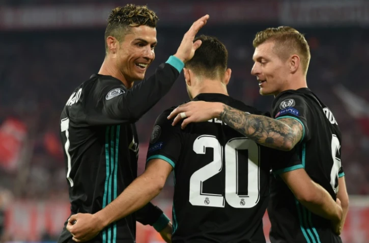 Le milieu du Real Madrid Marco Asensio est congratulé par Cristiano Ronaldo (g) et Tony Kroos après son but face au Bayern en demi-finales de C1, le 25 avril 2018 au Bayern