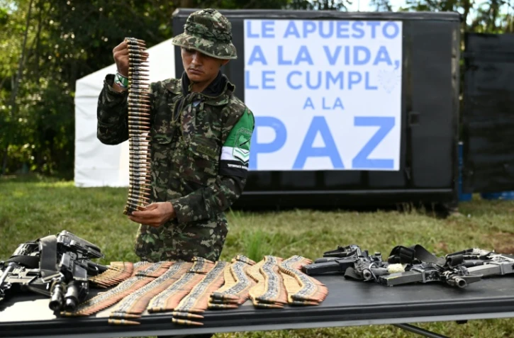 Un membre de la Coordination nationale Armée bolivarienne (CNEB) dépose les armes lors d'une cérémonie de désarmement dans la commune de Valle del Guamuez, dans le département du Putumayo, en Colombie, le 18 juin 2026