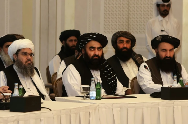 Les membres talibans Shahabuddin Delawar (g), Amir Khan Muttaqi (c) et Khairullah Khairkhwa (d) lors d'une rencontre avec des diplomates étrangers, le 12 octobre 2021 à Doha, au Qatar