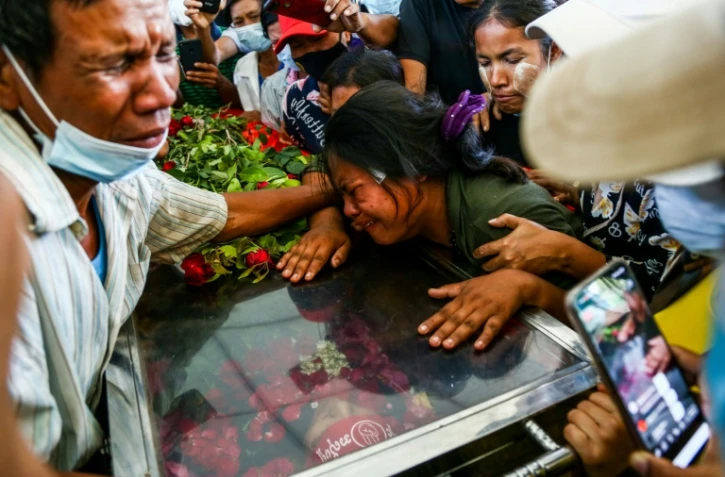 La femme de Phoe Chit, tué lors d'une manifestation pro-démocratie, pleure sur le cercueil lors des funérailles à Rangoun, le 5 mars 2021
