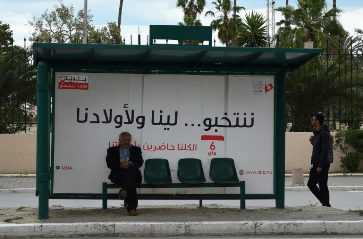 "Nous votons... pour nous et pour nos enfants". Un slogan inscrit sur une affiche à un arrêt de bus à Tunis, avant les municipales de dimanche, le 4 mai 2018