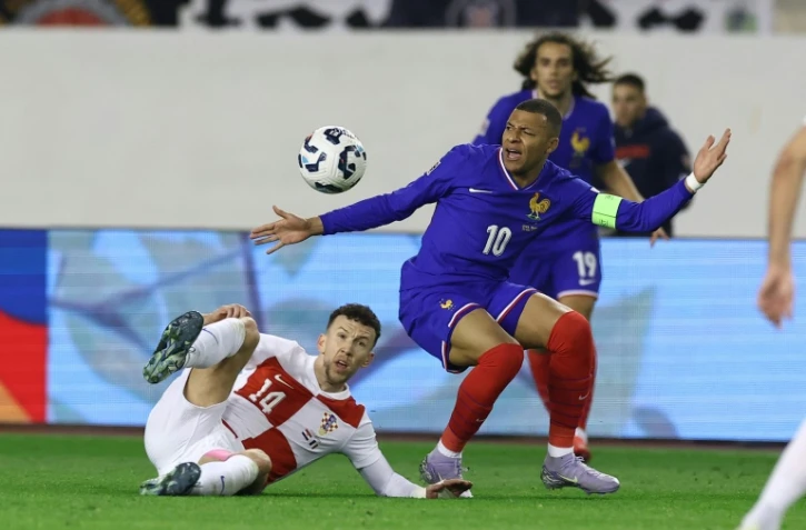 L'attaquant des Bleus Kylian Mbappé (D) au duel avec le Croate Ivan Perisic, à Split en Croatie, le 20 mars 2025
