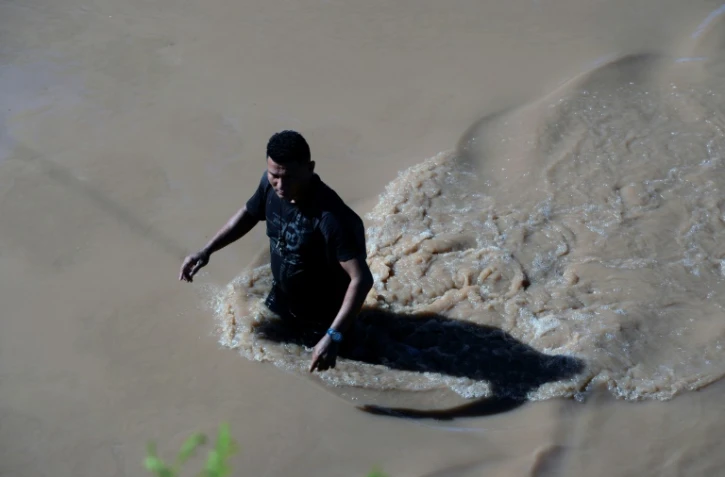Dans une rue inondée de la ville de El Progreso (Honduras) un homme tente d'avancer après le passage de la tempête Eta, le 7 novembre 2020