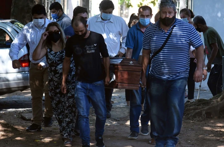 Une famille porte le cercueil d'un de ses membres, décédé du covid, le 10 avril 2021 à Asuncion (Colombie)