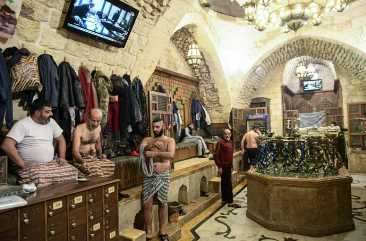 Des hommes se sèchent après s'être baignés au hammam El-Qawwas, un bain turc traditionnel à Alep, dans le nord de la Syrie, le 16 décembre 2021