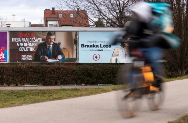 Un homme à vélo passe devant une affiche électorale du président croate sortant et candidat à la présidentielle, Zoran Milanovic, à Zagreb, le 9 janvier 2025