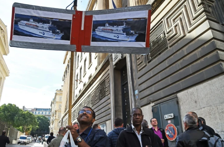 Un employé de la SNCM brandit des affiches des navires de la compagnie, le 25 septembre 2015 devant le palais de justice de Marseille