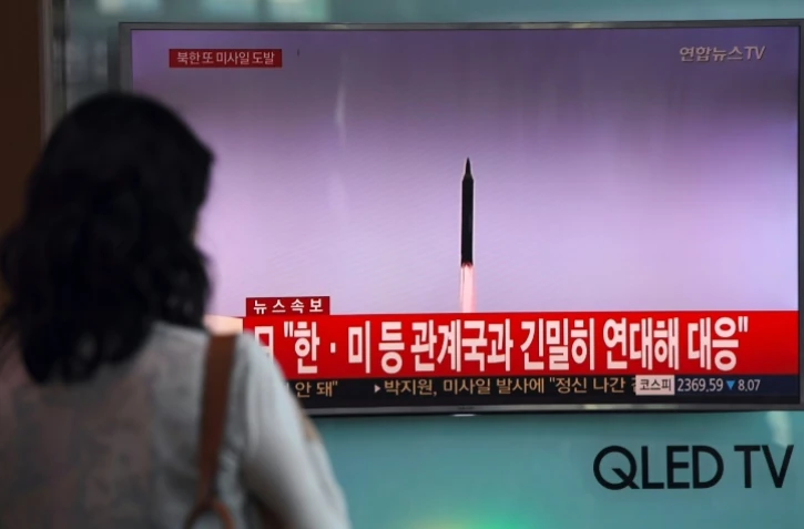 Une Sud-Coréenne regarde sur un écran de télévision le tir de missile nord-coréen, dans une gare de Séoul, le 15 septembre 2017