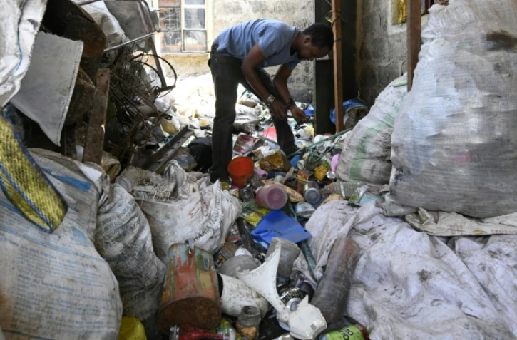 L'artiste kényan Evans Ngure cherche des matériaux dans des poubelles à Nairobi, le 2 août 2018