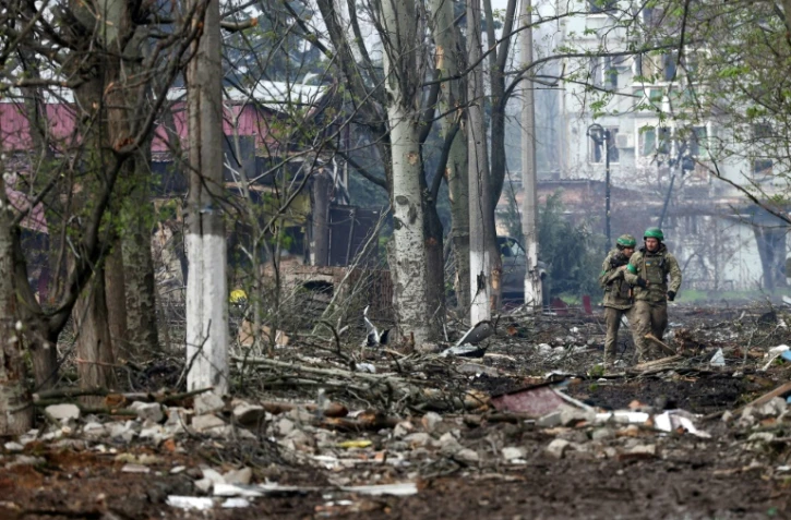 Des soldats ukrainiens marchent à travers les ruines de Bakhmout, dans l'est de l'Ukraine, le 23 avril 2023