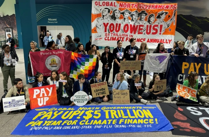 Des militants pour l'environnement manifestent silencieusement à la COP29 à Bakou pour demander aux pays riches de financer l'aide climatique pour les pays en développement, le 16 novembre 2024