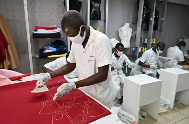 Des employés d'une société de mode fabriquent des masques de protection contre le nouveau coronavirus à Abidjan, le 9 avril 2020 en Côte d'Ivoire