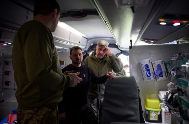 Le président ukrainien Volodymyr Zelensky (au centre) visite un hôpital ambulant à Avdiivka, dans l'est de l'Ukraine, le 18 avril 2023