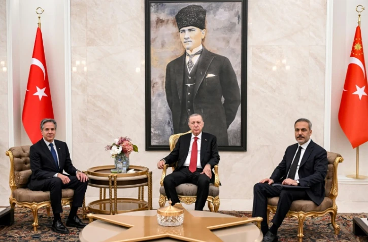 Le chef de la diplomatie américaine Anthony Blinken (G) avec le président turc Recep Tayyip Erdogan (C) et le ministre des Affaires étrangères turc, Hakan Fidan, le 12 décembre 2024 à l'aéroport d'Ankara