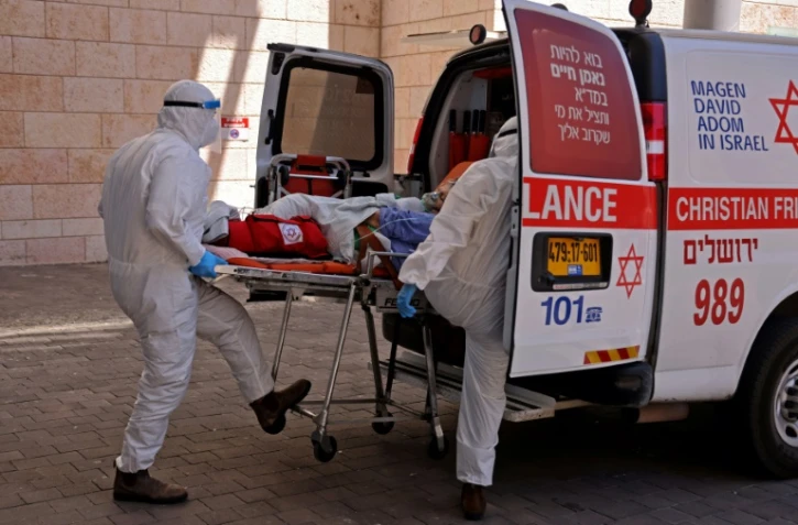 Des ambulanciers transportent un malade atteint du Covid-19 dans un hôpital de Jérusalem, le 15 août 2021
