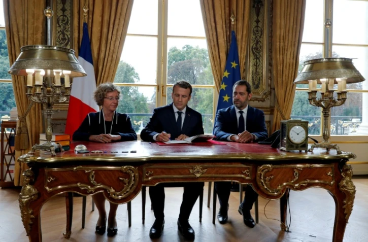 Le président Macron signe le 22 septembre 2017, entouré de Muriel Pénicaud, ministre du Travail, et de Christophe Castaner, ministre des Relations avec le Parlement, les ordonnances instaurant un barème des indemnités prud'homales