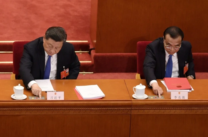 Le président chinois Xi Jinping (G) et le Premier ministre Li Keqiang votent sur une mesure prévoyant une loi sur la sécurité à Hong Kong, lors de la séance de clôture d'une session du Parlement à Pékin, le 28 mai 2020