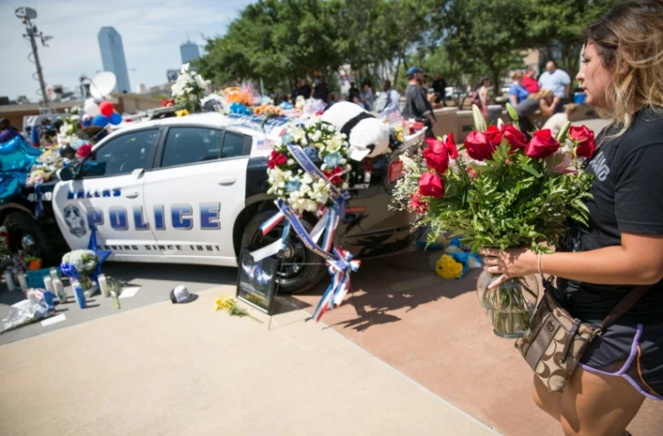 Des fleurs sur une voiture de police en hommage aux policiers tués, le 8 juillet 2016 à Dallas