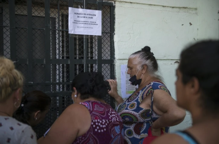 Des personnes attendent devant l'entrée de l'association "entre amis" à Séville, le 29 juin 2020