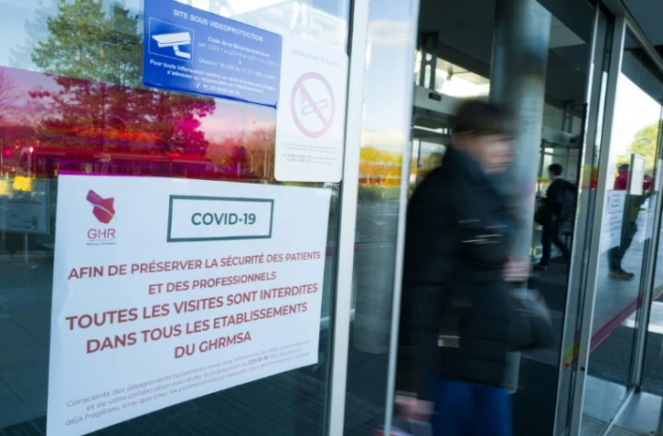 Une personne passe à côté d'une affiche sur les mesures à suivre pendant l'épidémie de Covid-19 à l'hôpital Emile Muller, le 8 mars 2020 à Mulhouse