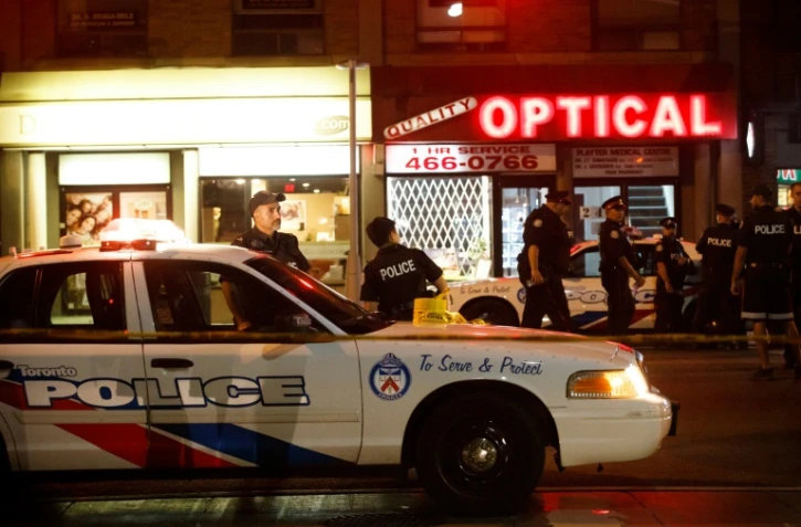 Des policiers de Toronto dans Danforth Street, sur la scène de la fusillade qui a fait deux morts, le 23 juillet 2018 au Canada