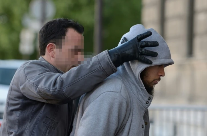 Alexandre Dhaussy, qui a poignardé un militaire à la Défense, escorté par un policier le 29 mai 2013 à Paris