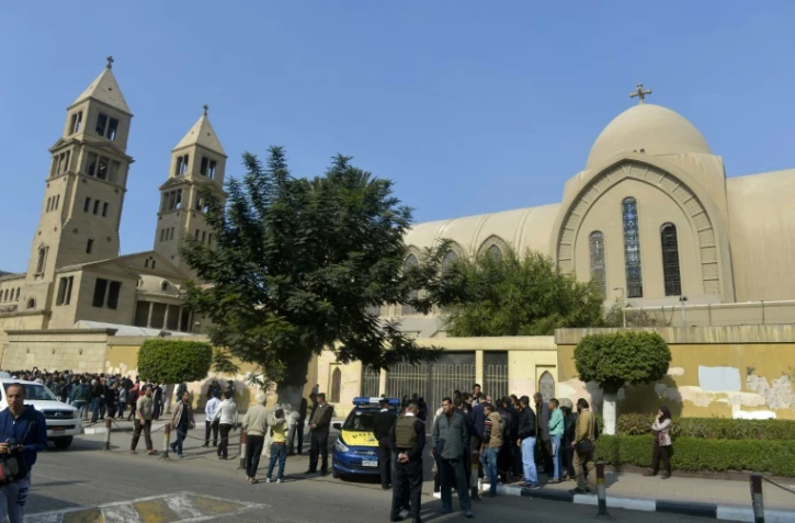 Policiers et passants sont devant l'église copte du Caire où une explosion a eu lieu, le 11 décembre 2016 