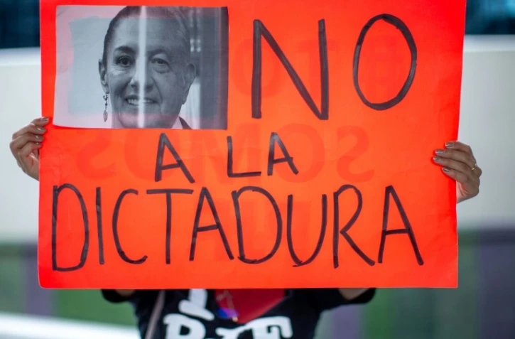 Une femme tient une pancarte "Non à la dictature" pendant une manifestation contre le pouvoir en place à Monterrey dans le nord du Mexique, le 4 octobre 2024