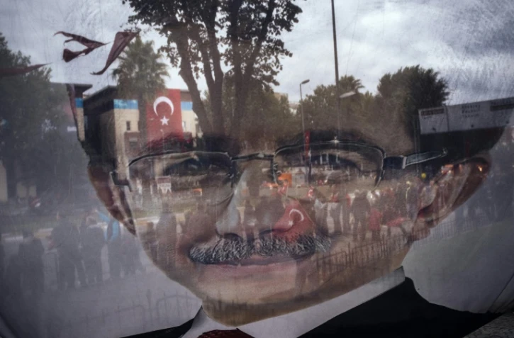 Photo prise à travers une banderole électorale tranparente affichant un portrait du Premier ministre turc Ahmet Davutoglu le 29 octobre 2015 à Istanbul