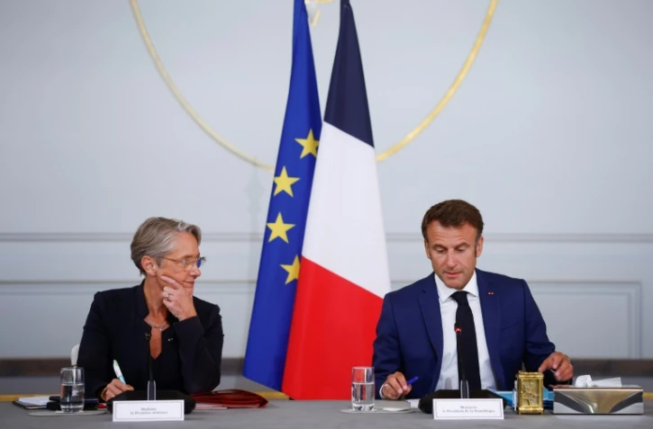 La Première ministre Elisabeth Borne (G) écoute le président Emmanuel Macron (D) au palais de l'Elysée à Paris le 19 juillet 2023