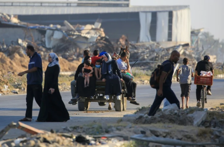 Des Palestiniens prennent la route à Al-Maghazi alors qu'ils fuient leurs camps de déplacés à cause des bombardements israéliens sur le centre de la bande de Gaza, le 5 juin 2024