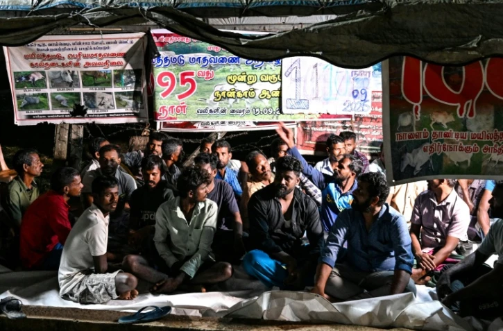 Des éleveurs tamouls installés sous une bâche pour protester contre une spoliation foncière, le 30 septembre 2026 à Batticaloa, dans l'est du Sri Lanka