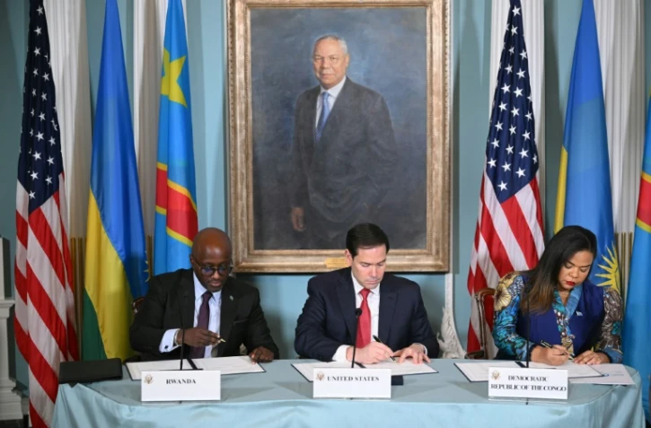 Le secrétaire d'Etat américain Marco Rubio (c),  la ministre de la RDC Thérèse Kayikwamba Wagner et le ministre rwandais Olivier Nduhungirehe signent un accord de paix, le 27 juin 2025 à Washington